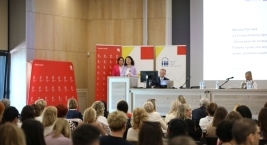 Zdjęcie przedstawia osobę przemawiającą przy mównicy podczas 
Forum Pomocy Społecznej oraz uczestników
