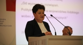 Zdjęcie przedstawia osobę przemawiającą przy mównicy podczas Forum Pomocy Społecznej